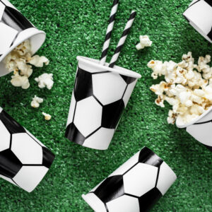 Trink- und Popcornbecher mit Fußballmuster und schwarzweiß gestreifte Strohälme